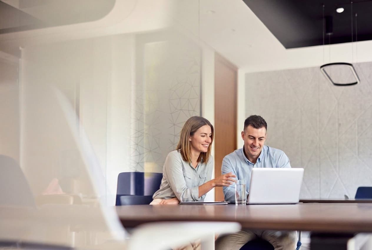 Two professionals aligning on goals in a bright meeting room